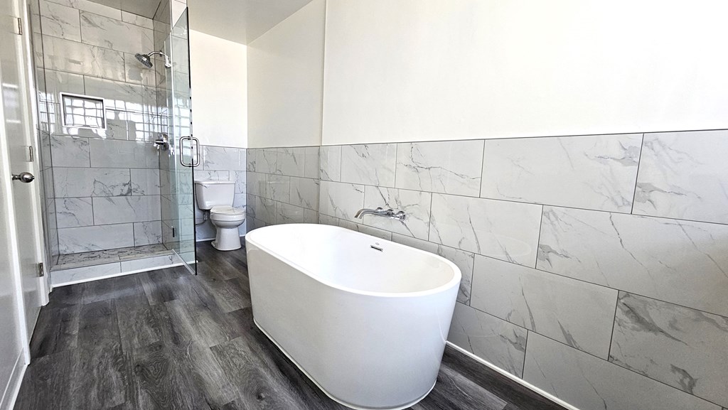 a white bathroom with a large tub and a shower