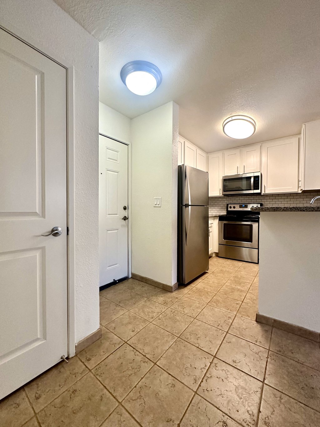 a kitchen with stainless steel appliances and white cabinets