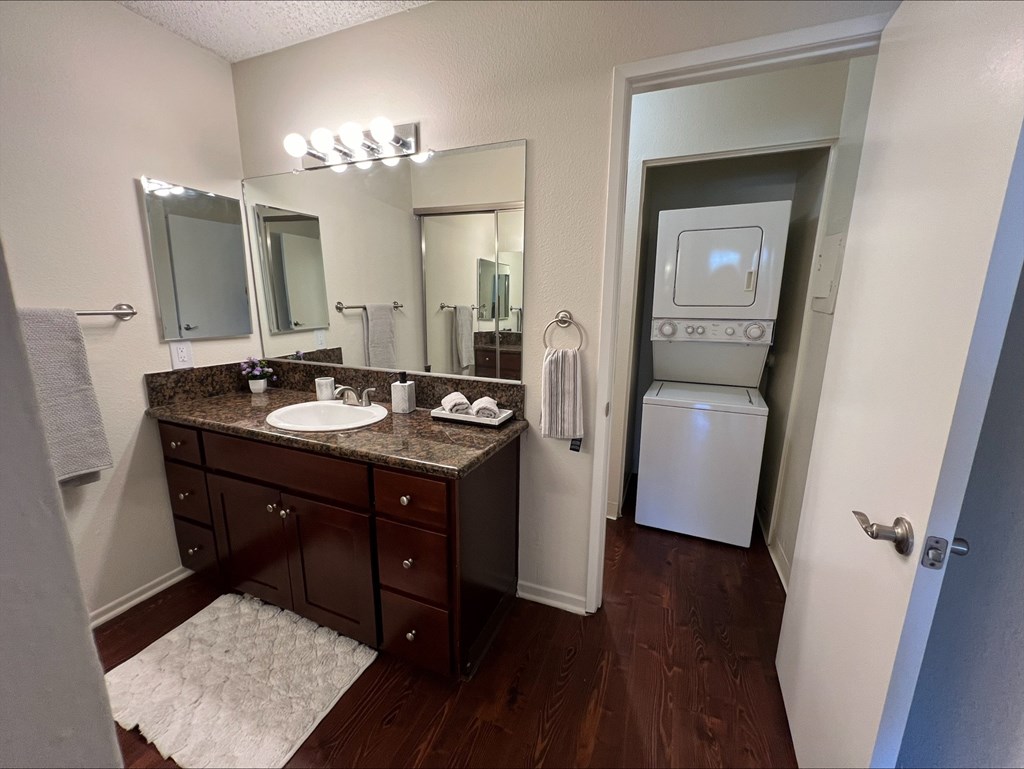 A bathroom with a brown vanity and a white towel.