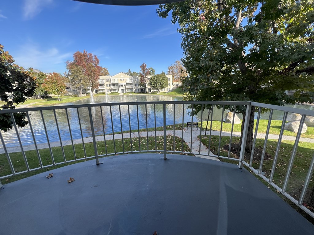 A balcony overlooks a body of water with a building in the background.