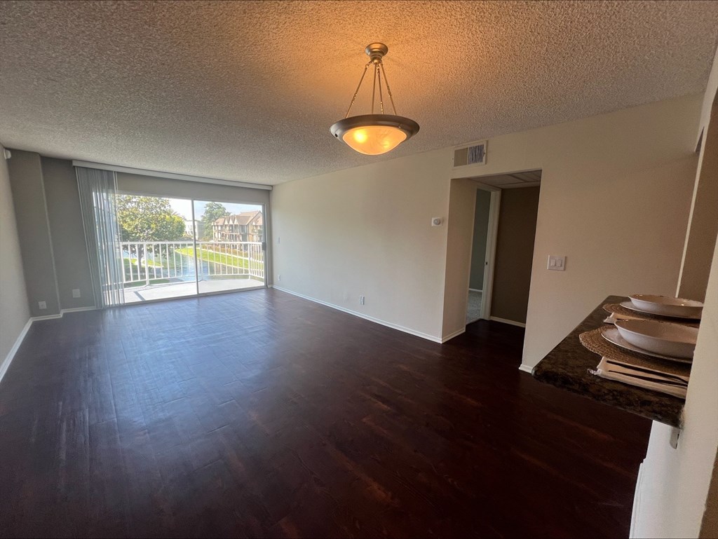 A room with a wooden floor and a sliding glass door.
