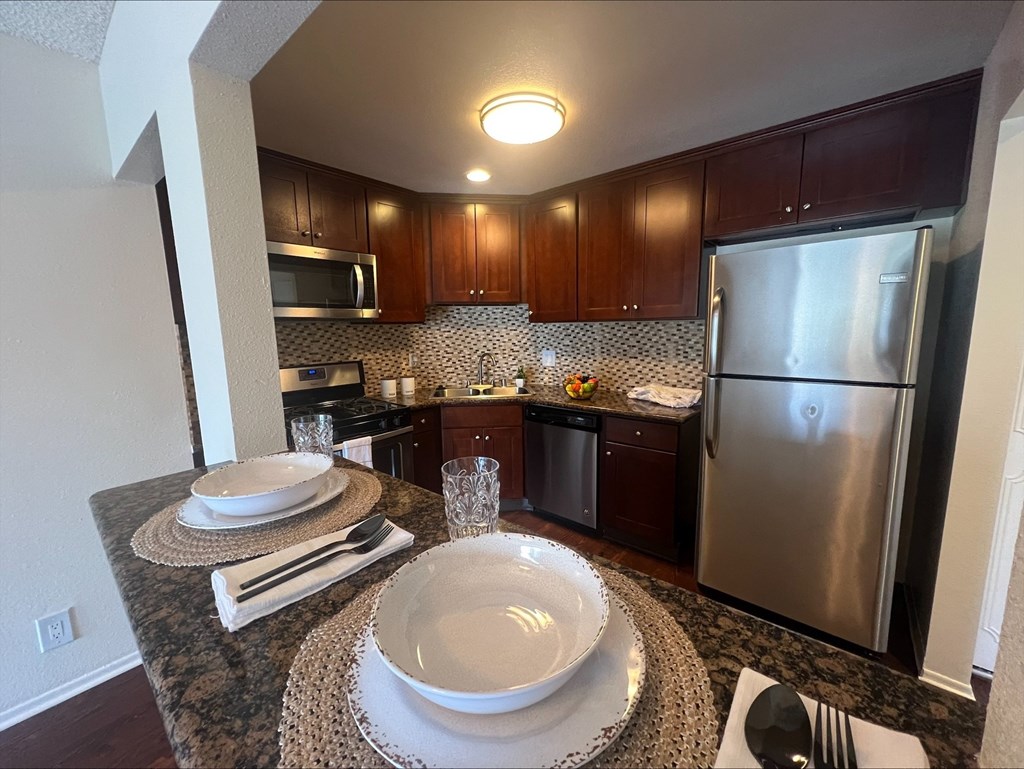 A kitchen with a refrigerator, microwave, and dishwasher.