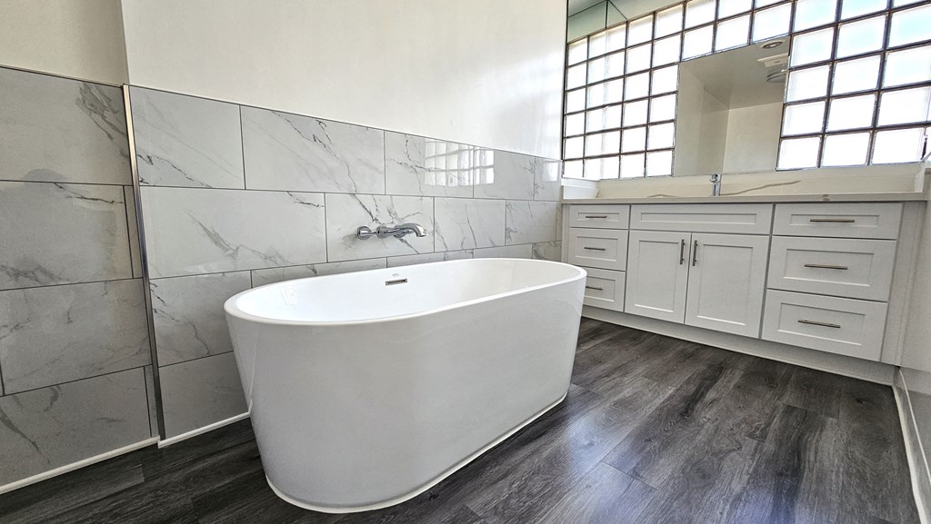 a large white bathroom with a large tub in the center