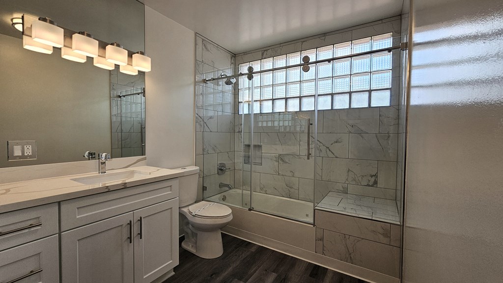 a bathroom with a shower and a sink and a toilet