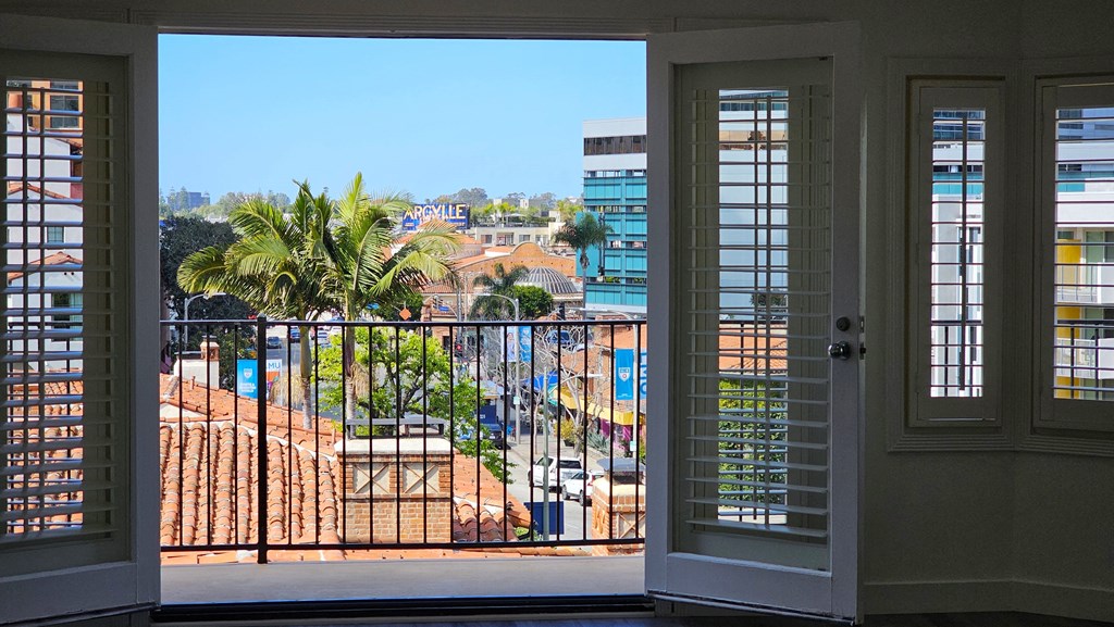 the view from the window of an apartment in a building with palm trees