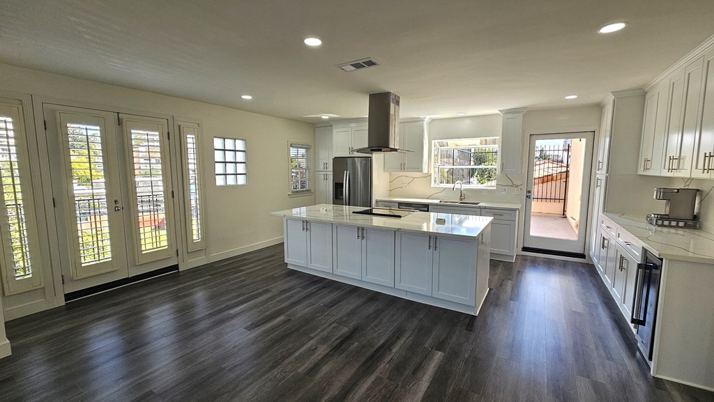 a kitchen with white cabinets and a large island
