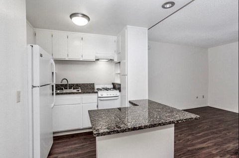 a kitchen with white appliances and a granite counter top