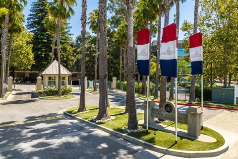 a park with flags and trees and a fountain