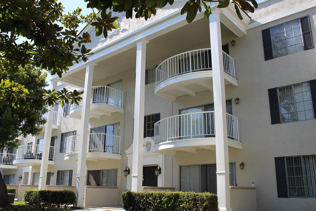 A white apartment building with balconies and windows.