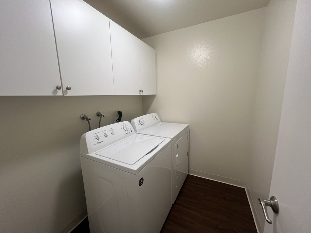 A white washing machine in a small laundry room.