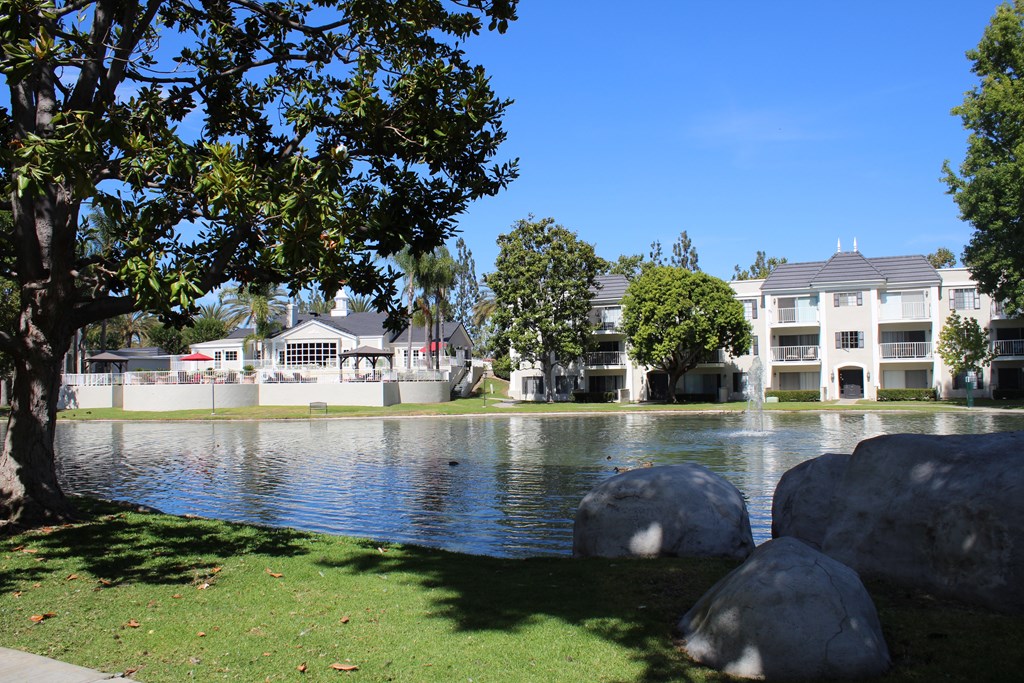 A serene lake surrounded by trees and houses.