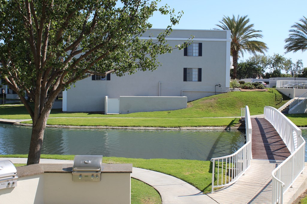 A white building with a tree in front of it.