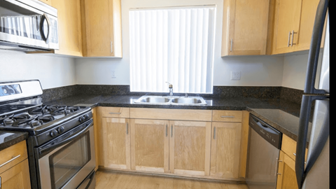 a kitchen with wooden cabinets and a stove and a sink