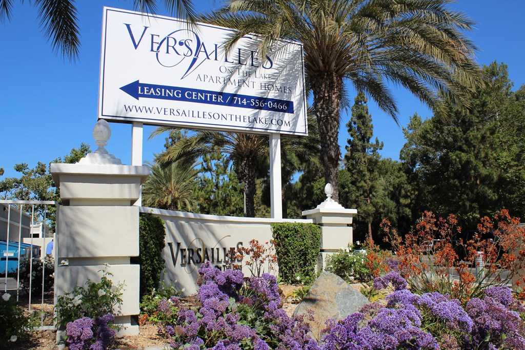 A Versailles Apartment Leasing Center sign is displayed in front of a building.
