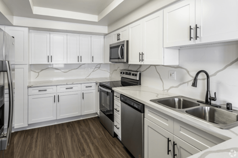 a kitchen with white cabinets and stainless steel appliances
