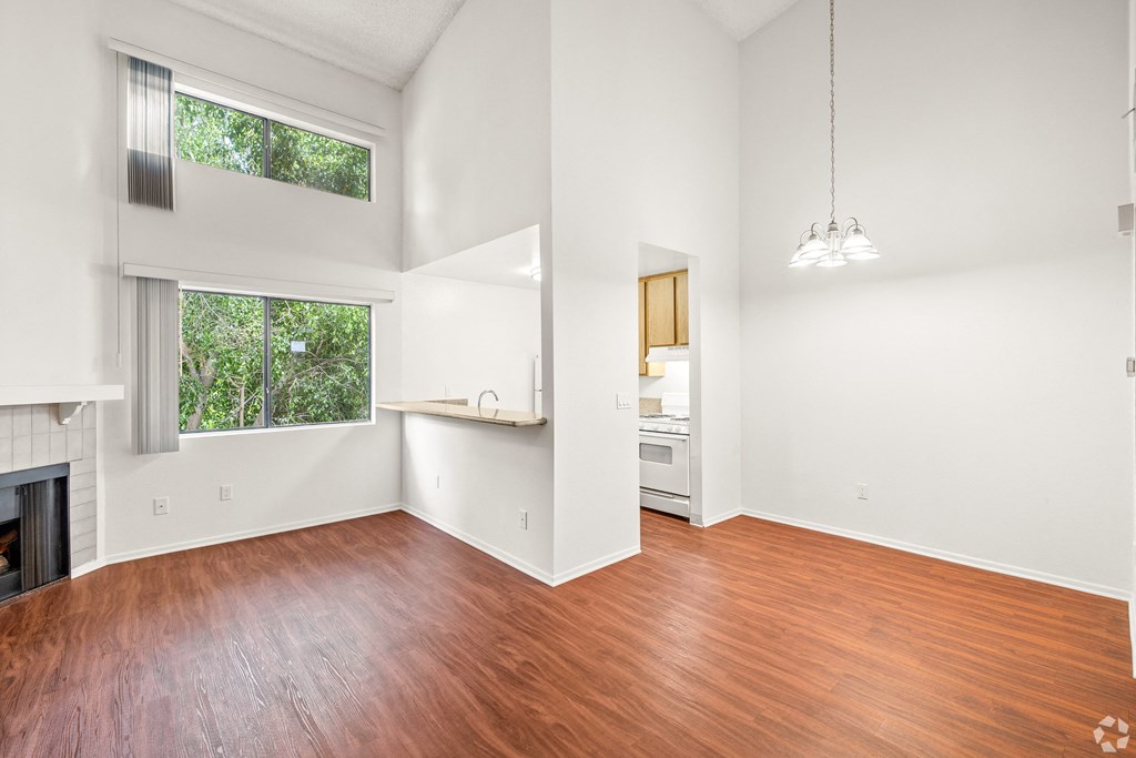 an empty living room with wood floors and a fireplace