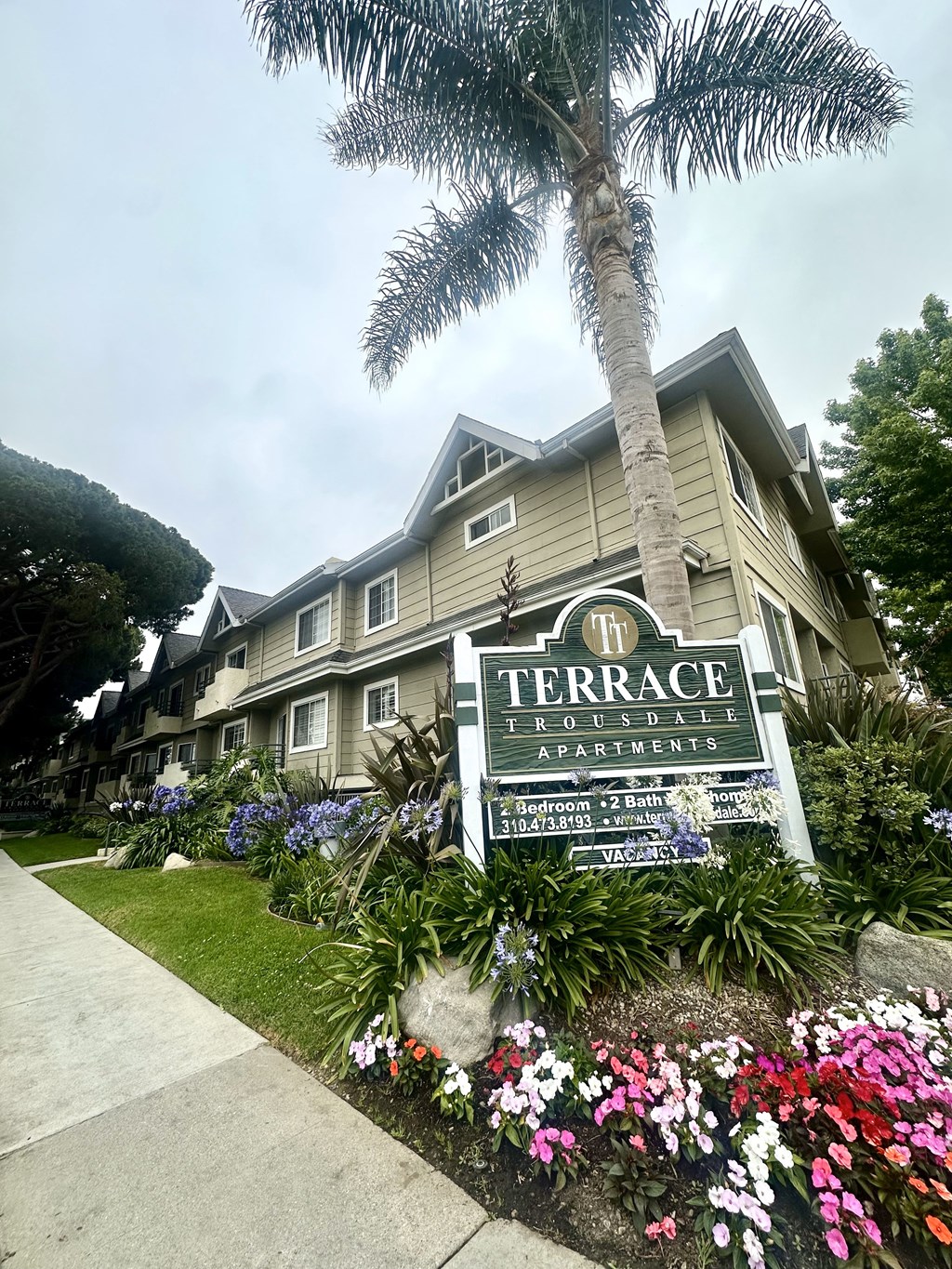A sign for Terrace Apartments is in front of a building.