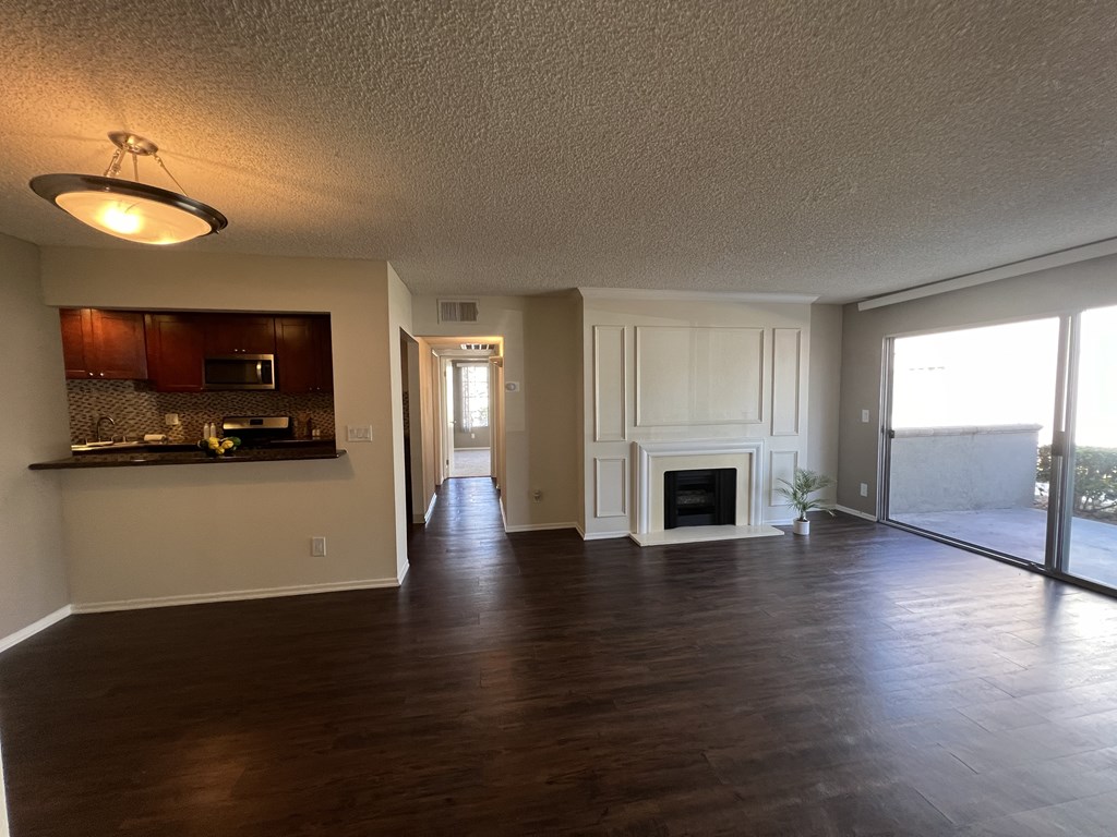 A spacious living room with a fireplace and sliding glass doors.