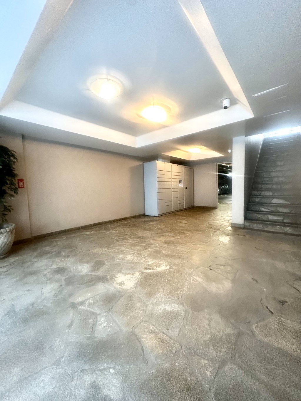 the lobby of a building with a marble floor and a staircase