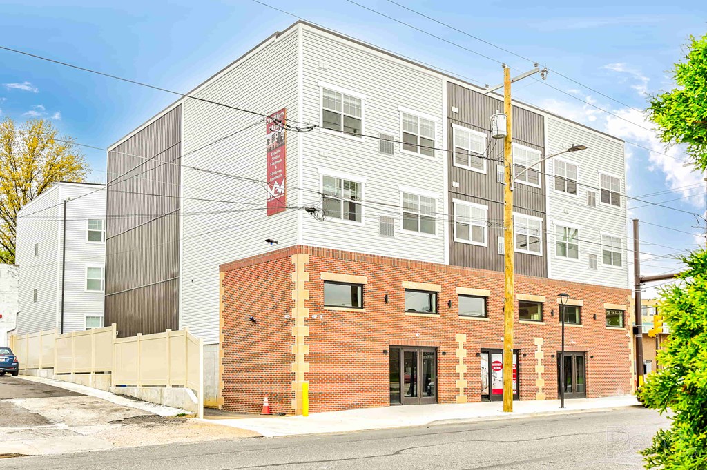 A modern building with a red brick section in front.