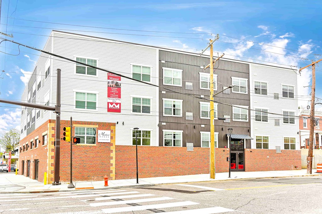 A street view of a building with a red brick wall and a sign that says "Veterans.".