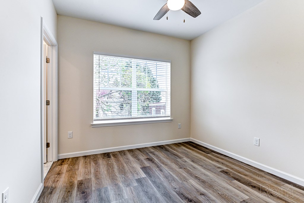 A room with a window and a ceiling fan.