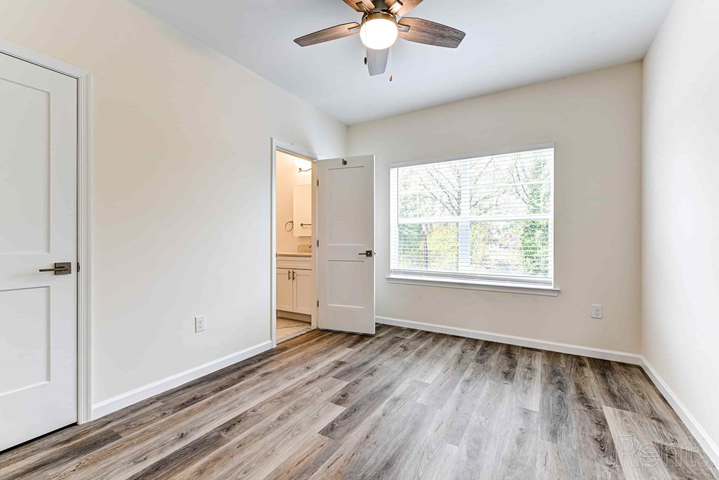 A room with a ceiling fan and a window.
