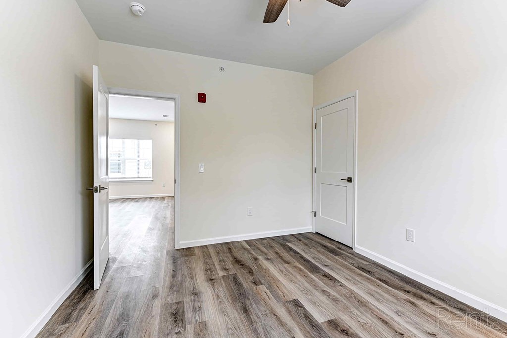 A room with a wooden floor and a ceiling fan.