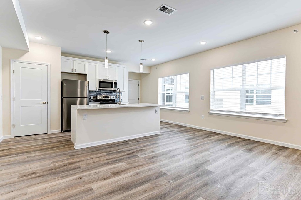 A kitchen with a refrigerator, microwave, and oven.