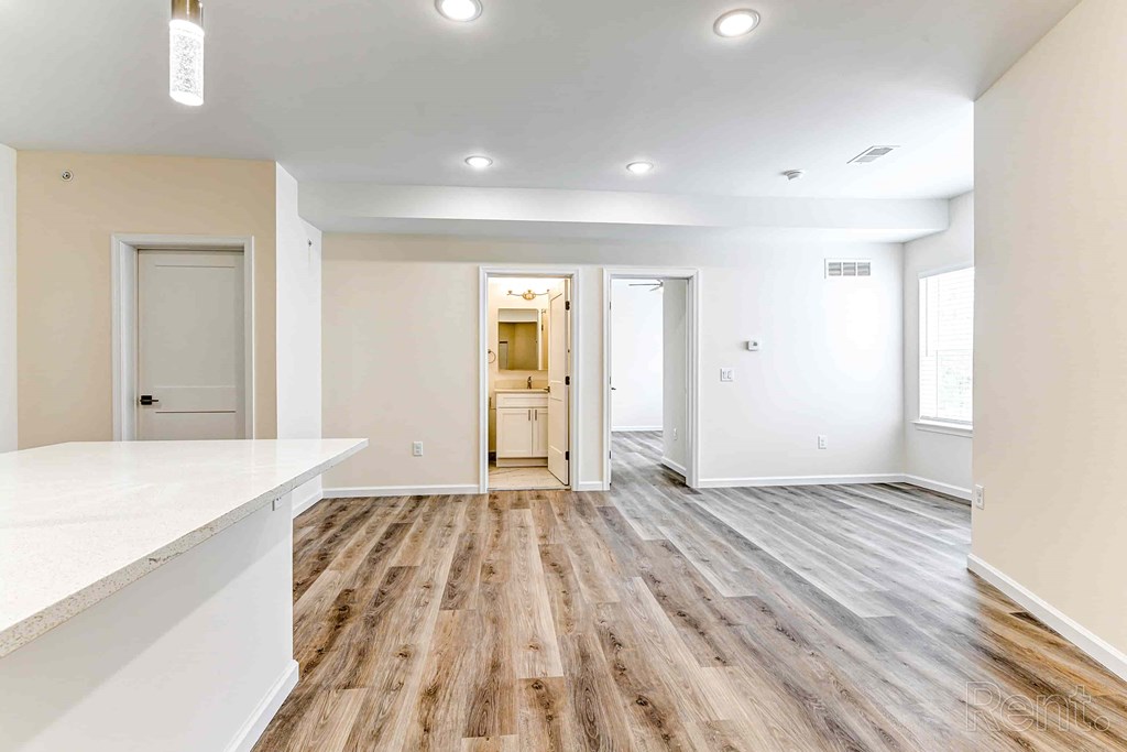 A spacious room with wooden flooring and white walls.