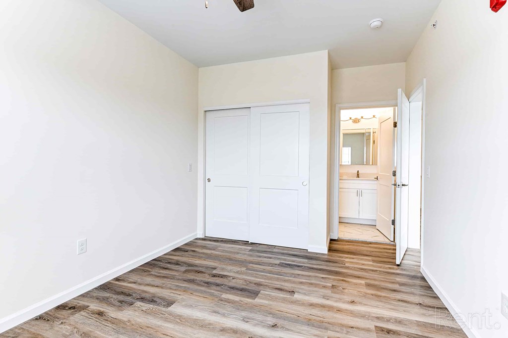 A room with a white door and a wooden floor.
