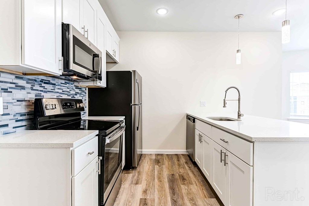 A kitchen with black appliances and white cabinets.