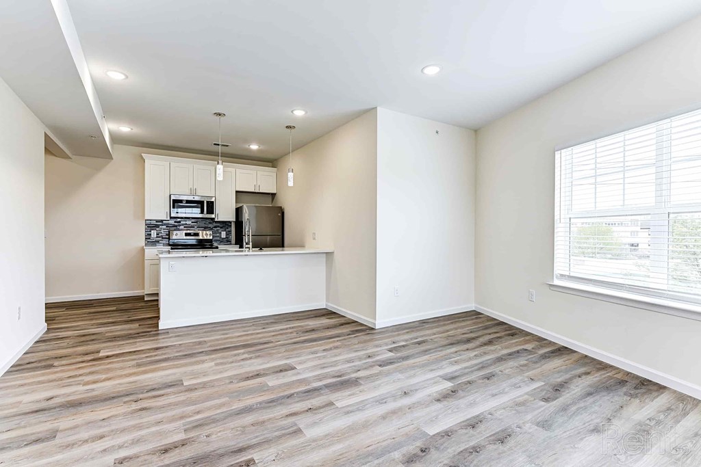 A kitchen with a refrigerator, microwave, and oven is shown in this image.