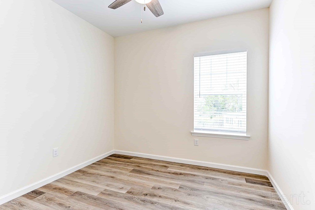 A room with a window and a ceiling fan.