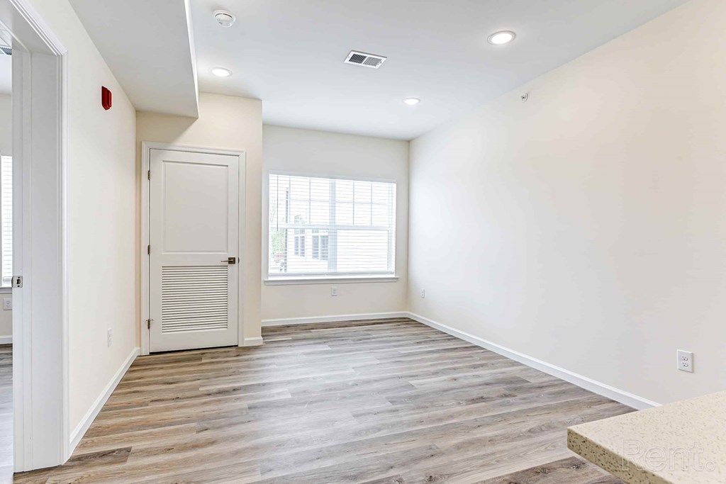 A room with a white door and a window with blinds.