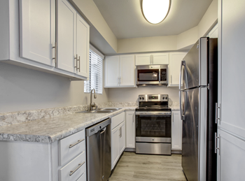 Upgraded Kitchen with subway tile backsplash, stainless steel appliance package and white cabinetry