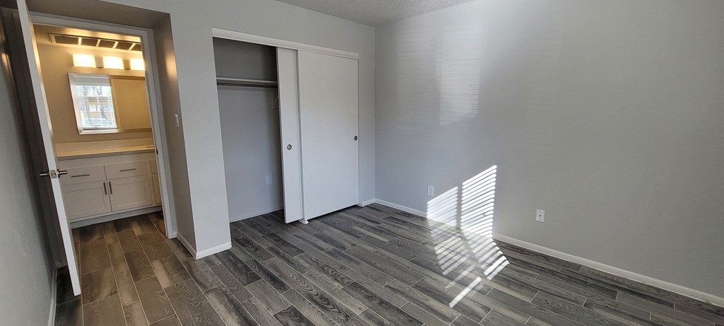 a living room with wood flooring and a door to a bathroom