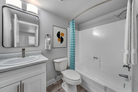 A white bathroom with a toilet, sink, and bathtub.