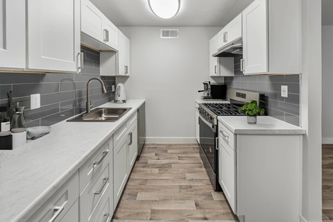 A kitchen with white cabinets and a black stove top oven.
