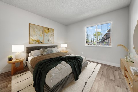 A bedroom with a large bed and a painting on the wall.