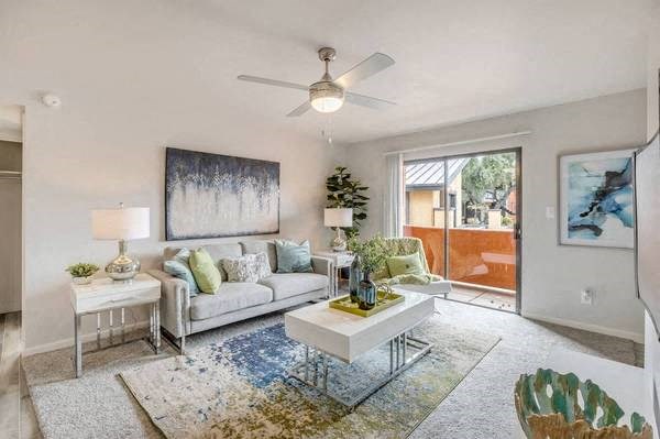 a living room with a white couch and a ceiling fan