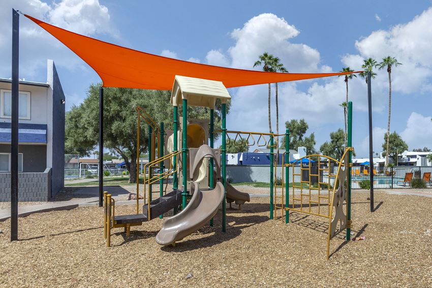 a playground with a swing set and slides at a park