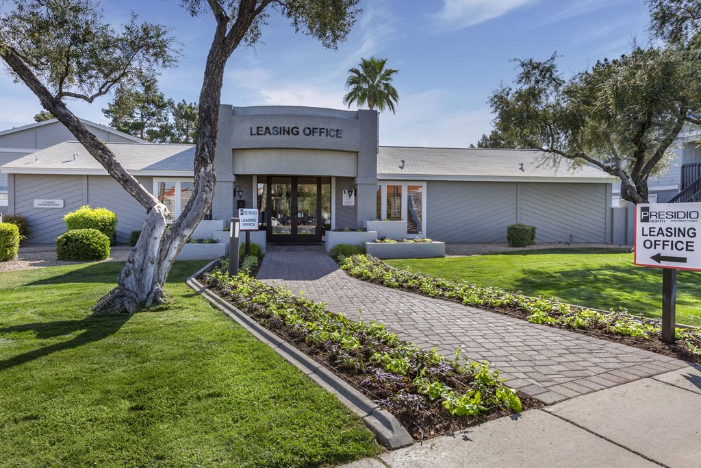 a building with a leasing office and a sign on the sidewalk