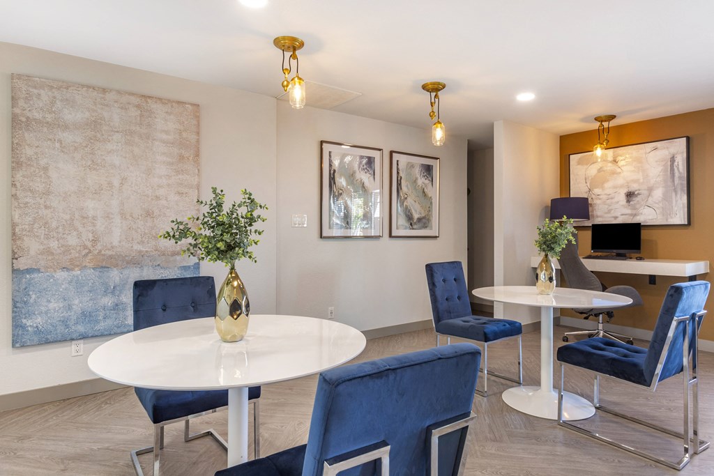 a dining room with blue chairs and a table with a vase of flowers