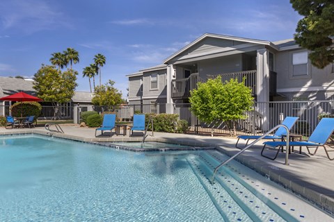 our apartments have a swimming pool with chairs and a house