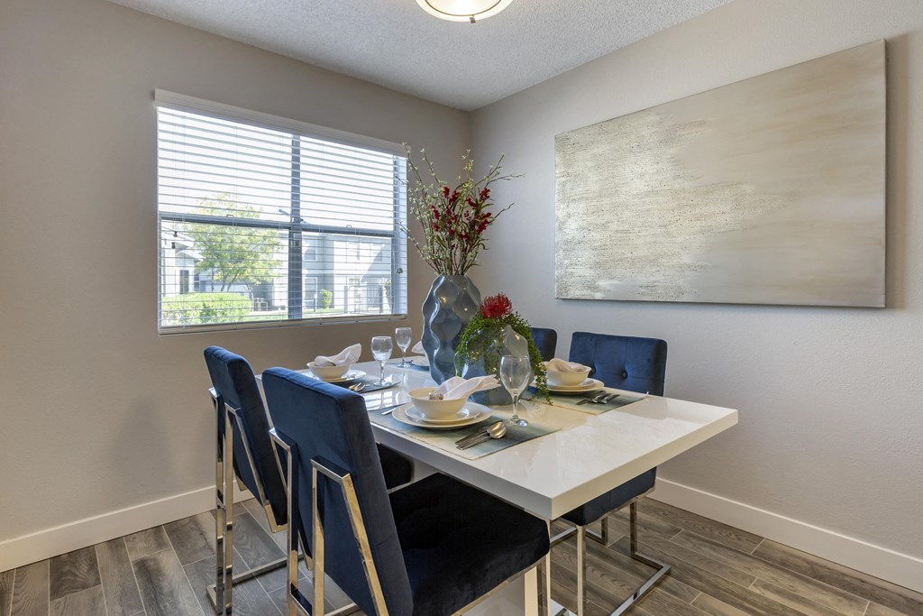 a dining room with a table and chairs and a large window