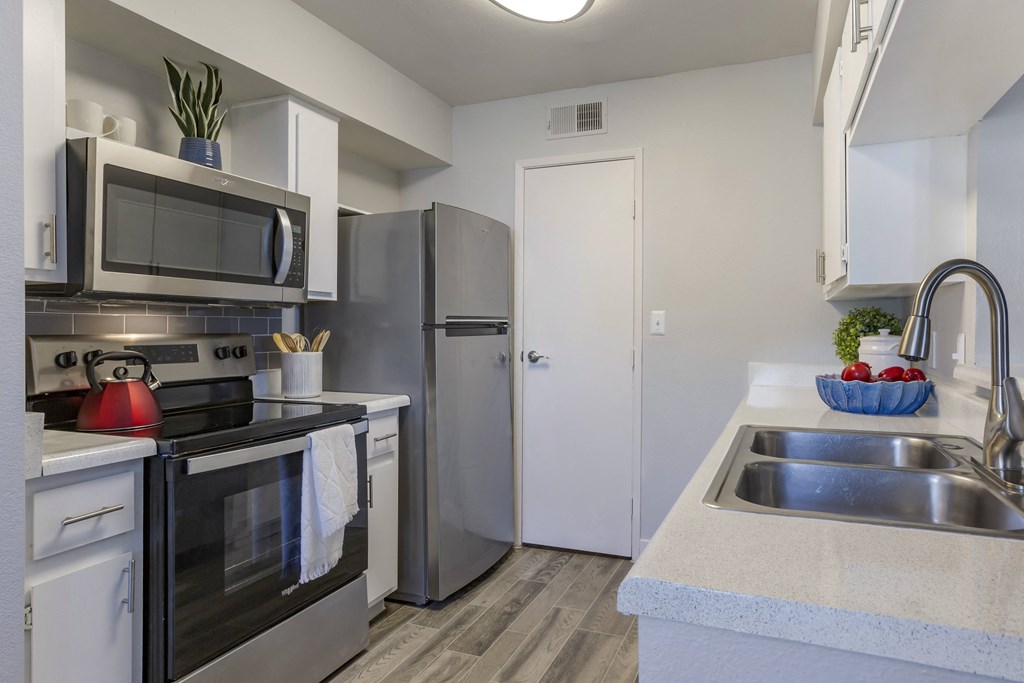 a kitchen with stainless steel appliances and a sink and a refrigerator
