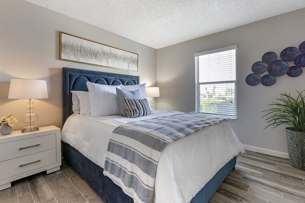 a bedroom with a blue and white bed and a window