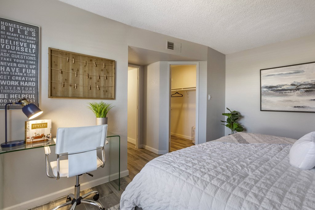 a bedroom with a bed and a desk with a chair