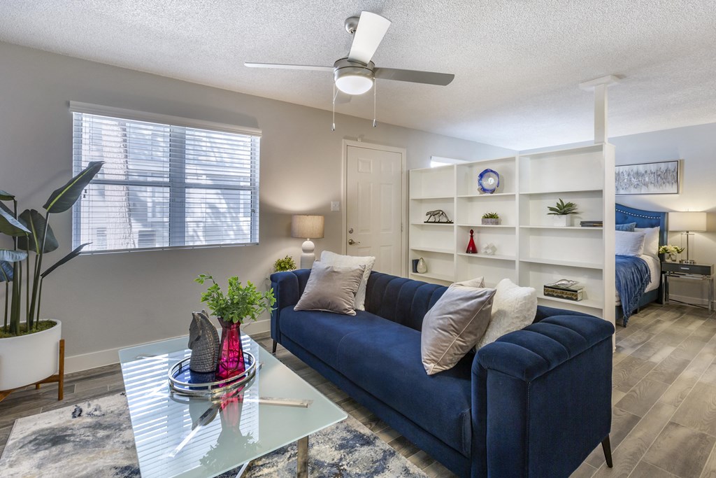a living room with a blue couch and a glass coffee table